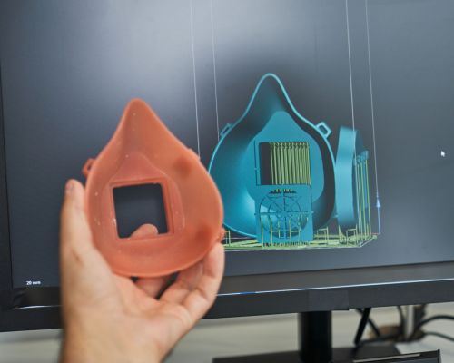 Unrecognizable person working on project of medical respirator and creating 3d model via program on professional computer in modern office